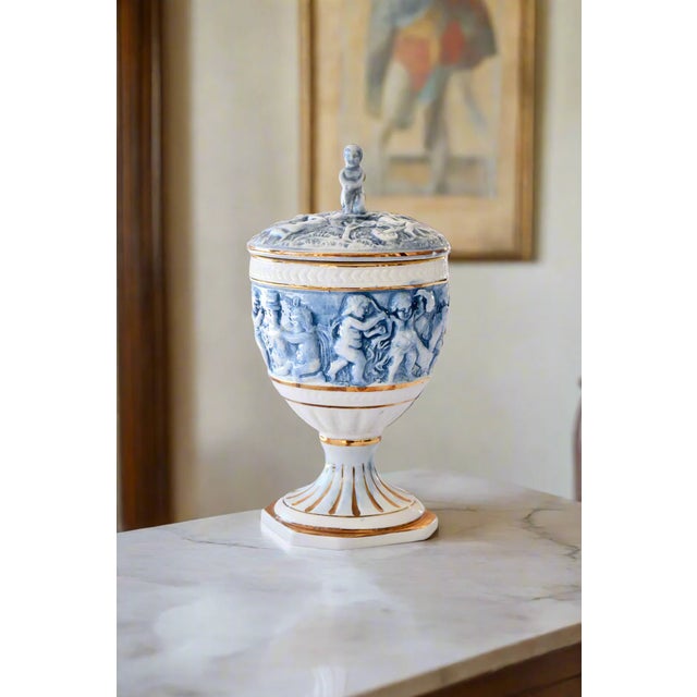 CAPODIMONTE CHERUB URN WITH LID Era: 1950s-1970s Maker: M.A.S. R. Capodimonte Origin: Italy OVERVIEW: A mid-century...