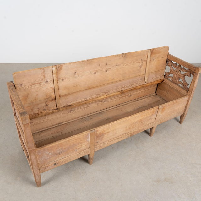 Swedish pine bench dated 1868, featuring a highly carved back and arms with wonderful country character. A carved heart at...