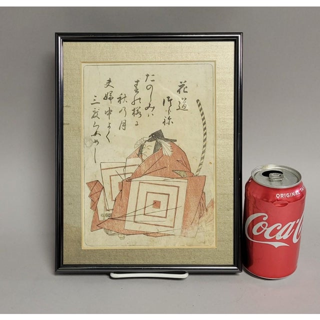 Striking Edo-period Japanese color woodblock print depicting a seated warrior in layered robes with stylized quiver or bow...