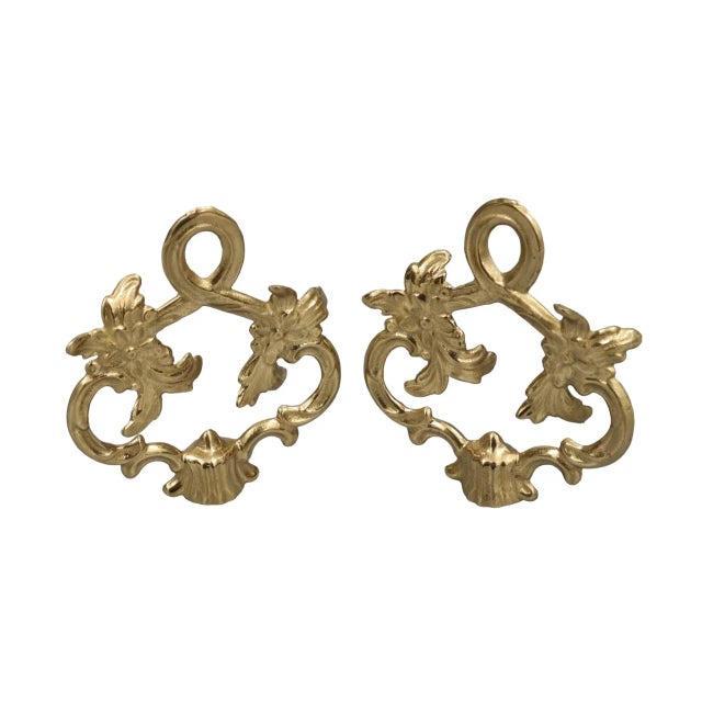 A pair of rocaille looped cast brass lamp finials. Cast with a loop above two acanthus floral sprays. Fits a standard size...