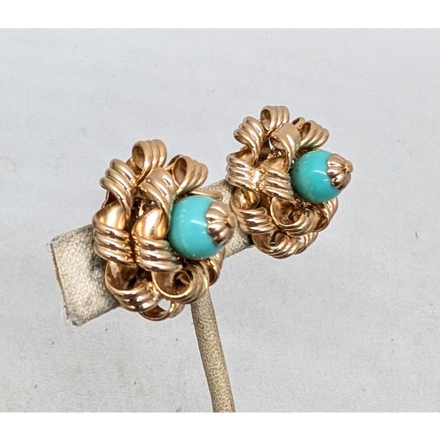 1950s goldtone curled "ribbon" edges with faux-turquoise bead center clip earrings. Marked "NAPIER PAT. PEND." Measure: 1...