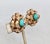 1950s goldtone curled "ribbon" edges with faux-turquoise bead center clip earrings. Marked "NAPIER PAT. PEND." Measure: 1...