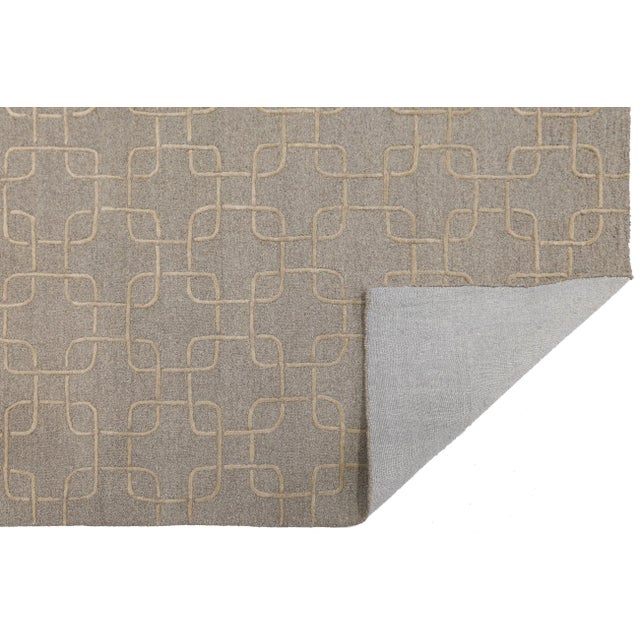 Elevate your living space with this sophisticated hand-tufted wool rug, featuring a contemporary interlocking geometric...