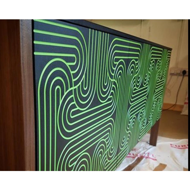The loop sideboard three door with black doors and a carved pattern hand painted in gold. this piece will add a...