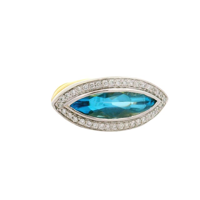 A striking fashion ring featuring a 4.50 carat cabochon-marquise shape blue topaz. The topaz displays a vivid blue hue,...