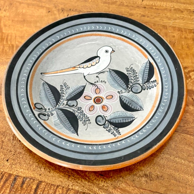 Mexican Tonala pottery plate with bird and botanical designs. Colors are a lovely orange, pink, light gray, and black....
