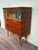 Vintage Italian cabinet with tall legs. Beautiful sliding glass doors with hand-painted decorations. The lower section is...