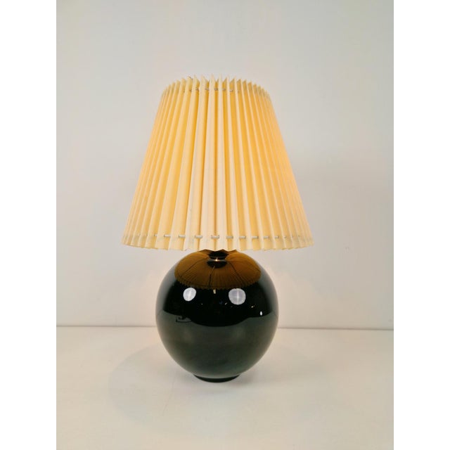 A black opaline glass spherical table lamp, in the style of jacques adnet, circa 1950s designer: jacques adnet - model:...