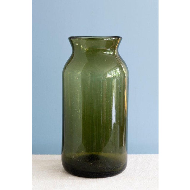 This 19th-century French glass pickling jar showcases a rich olive green colour. The attractive blown glass surface...