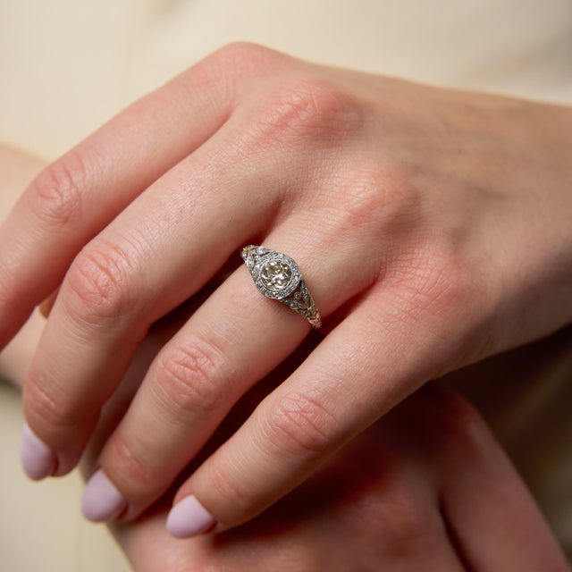 A striking Art Deco diamond ring that captures the refined geometry and intricate detail of the 1930s. At its center sits...