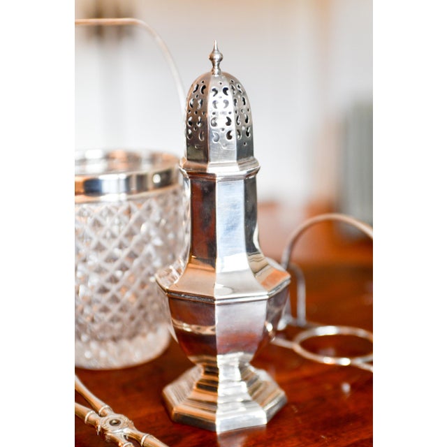 Celebrate British craftsmanship with this stunning 8.25-inch tall sterling silver muffineer measured to the top if its...