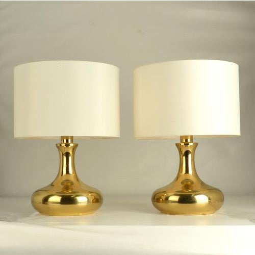 Pair of curvaceous brass table lamps, dating from the 1970s. Each lamp features a sculptural silhouette with softly...