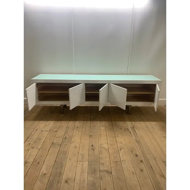 The Charlie credenza by Brueton is 19" x 84" x 29"H with a white high gloss finish and a 1/2" white laminated glass top....