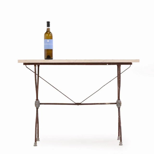 The weathered patina of the iron and subtle aging of the marble surface reflect the table's café provenance and early...