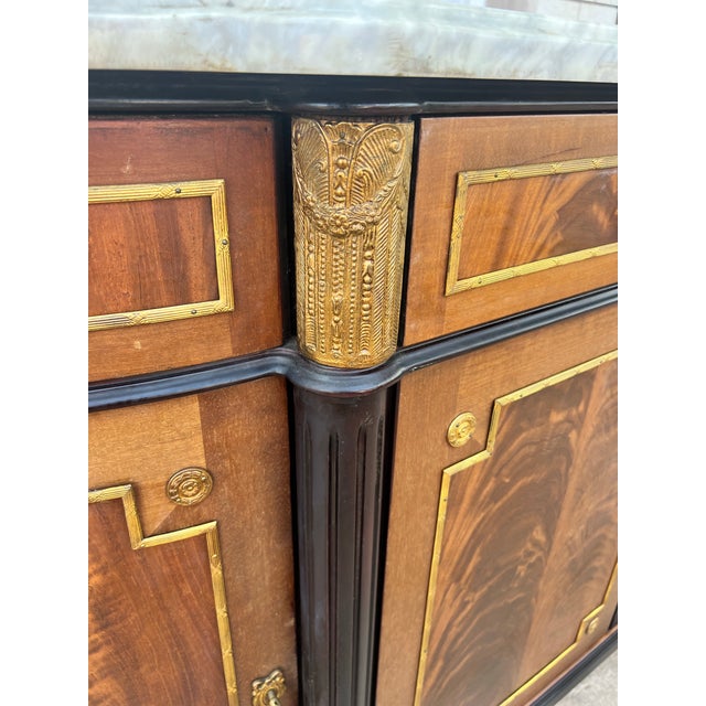 An elegant French 19th century Louis XVI sideboard crafted from beautifully figured flame mahogany and topped with a...