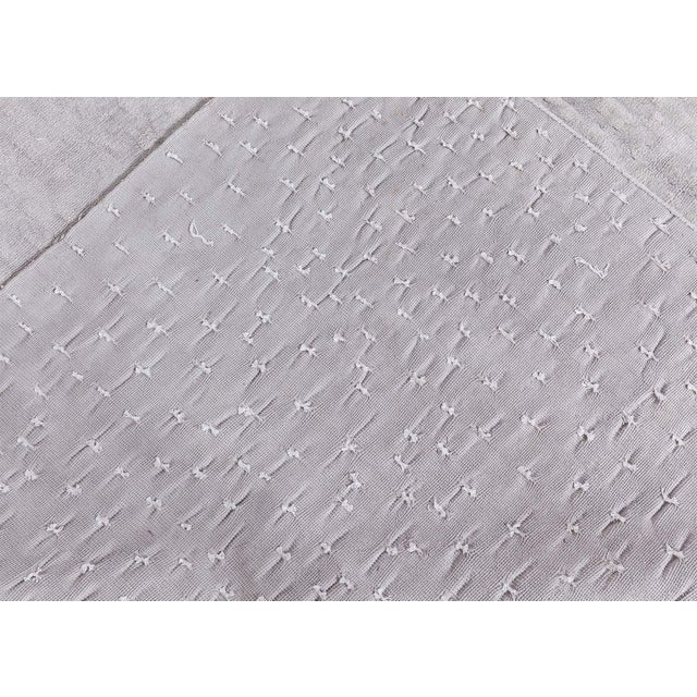 This contemporary silk mid century modern rug of ashen color fascinates the viewer with its irregular and soft pattern....