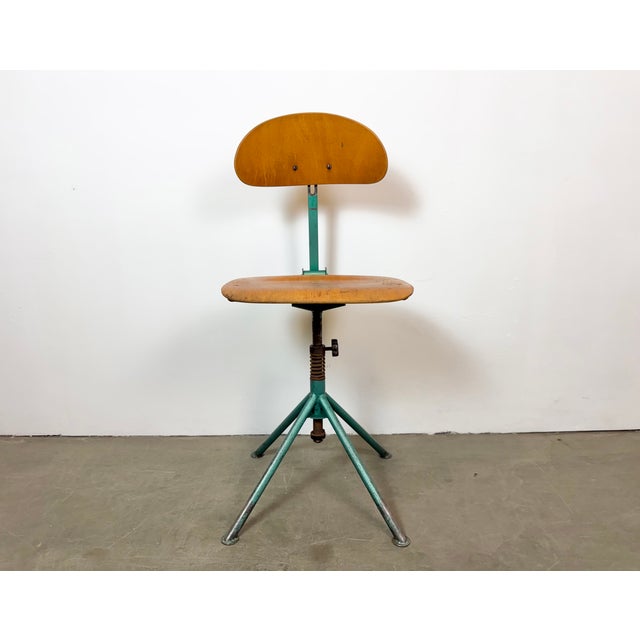 This industrial height adjustable, rotating chair was made in former Czechoslovakia during the 1950s.It features a dark...
