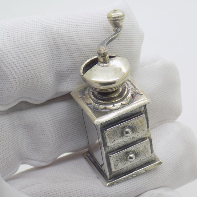 This vintage silver decorative object depicts a detailed coffee or pepper grinder miniature, crafted as a dollhouse...