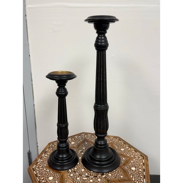 Design Plus Gallery presents a pair of Ebony Wood Pillar Candle Holders by Global Views. This graduated pair has turned...