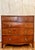 A handsome antique British chest featuring mahogany and walnut veneers with decorative inlay, richly figured drawer...