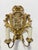 Carved in high relief and finished in a warm gilded surface, this matched pair of French wall sconces presents the...