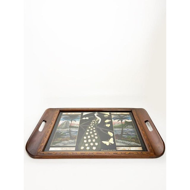 Decorative wooden serving tray dating from the 1970s. The rectangular tray features integrated handles and a richly...