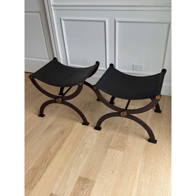 Timeless, sculptural, and impeccably crafted, this exceptional pair of French Empire style curule stools is a striking...