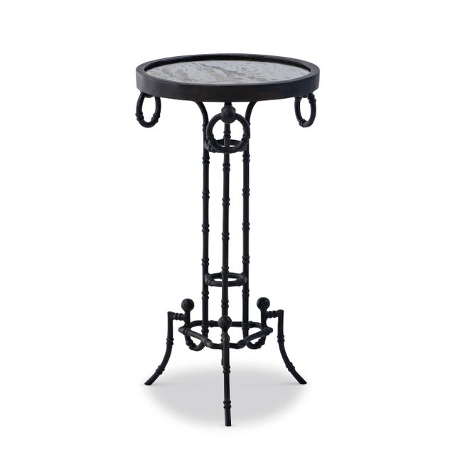 Intricately forged and full of character, this accent table features a round glass top supported by an iron base shaped...