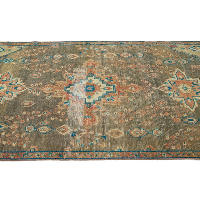 This vintage Persian Tabriz Hand-knotted wool rug has a gra field with multicolor accents in an all-over medallion design....