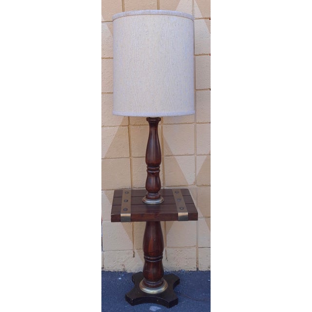 A Mid 20th Century Antiqued Pine Floor Lamp with Brass Accents Measures 18" in width, 15" in depth and 61" in height to...
