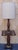 A Mid 20th Century Antiqued Pine Floor Lamp with Brass Accents Measures 18" in width, 15" in depth and 61" in height to...