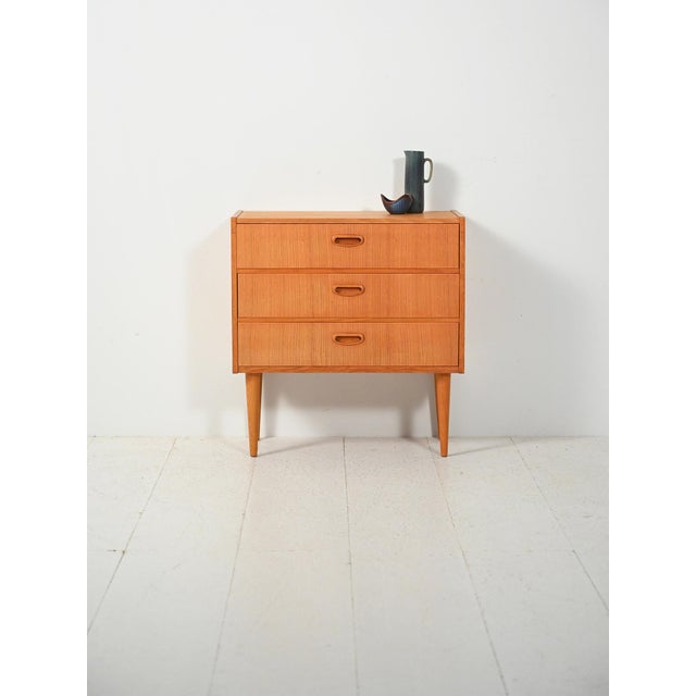 Scandinavian chest of drawers from the 1960s in oak, with three drawers, slender turned legs, and integrated carved...