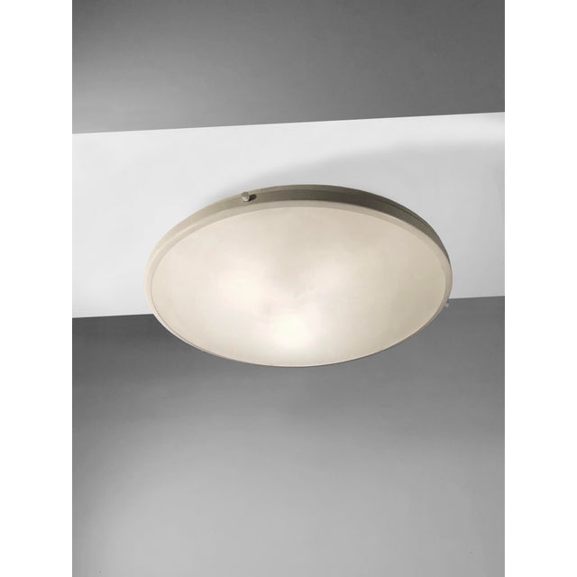 A rare and authentic circular ceiling light inspired by space, modernist, space-age, free-form, circular body with an...