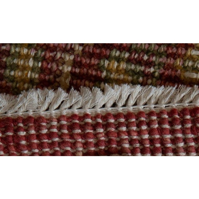 This hand knotted pile rug features a primary color palette of coral, salmon, and pink tones. Crafted from natural wool,...