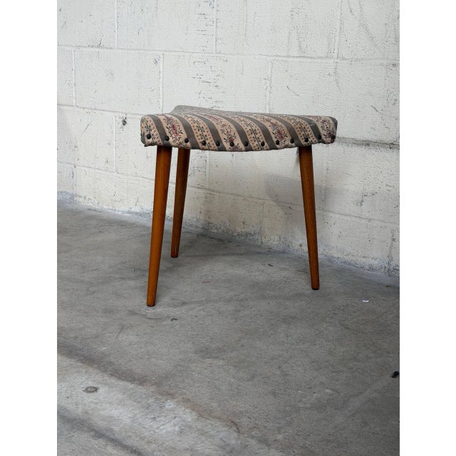 Vintage Danish Mid Century Modern corner ottoman stool featuring an unusual triangular form, tapered solid teak legs, and...