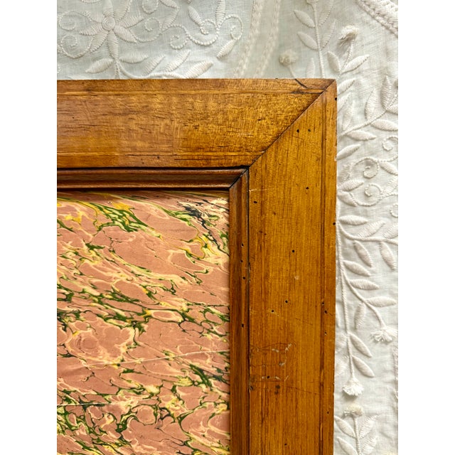 A charming antique French wood display frame featuring beautifully aged walnut-toned wood, delicate inner molding, and a...