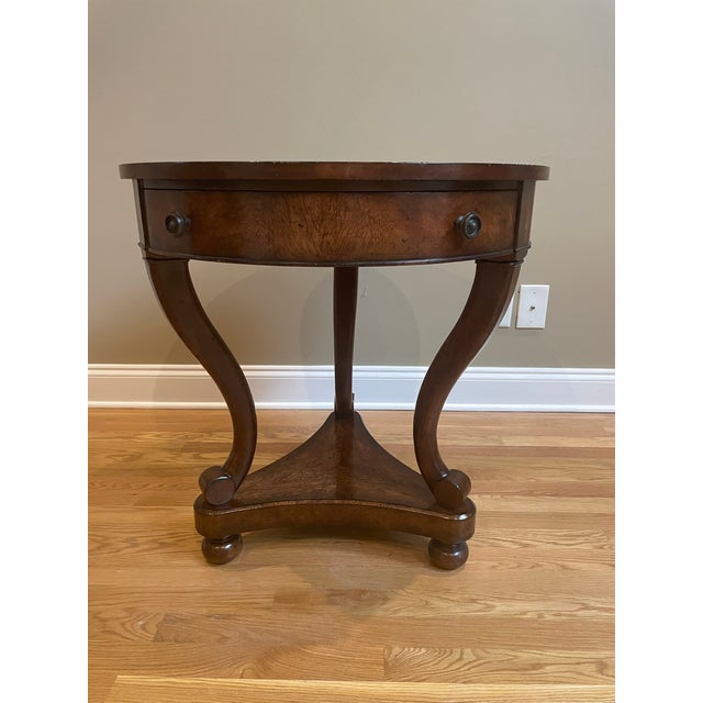 Cerejeira veneered and mahogany occasional table, the circular crossbanded top above a plain apron with a frieze drawer,...