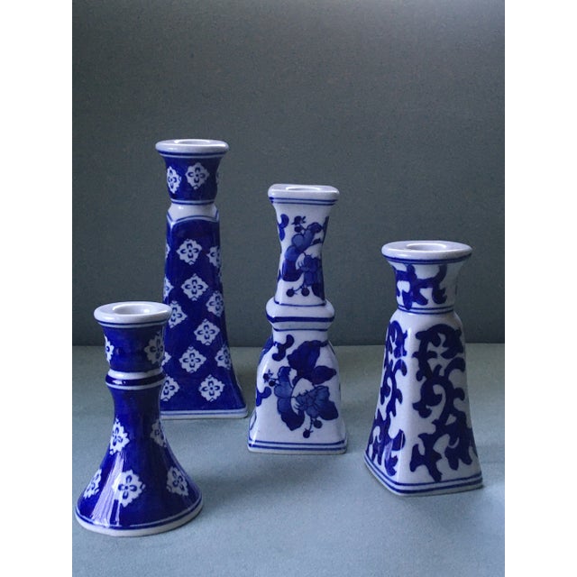 A set of four blue and white candlesticks in coordinated patterns. Tallest candlestick: 8 inches by 3 1/4 inches wide....