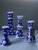 A set of four blue and white candlesticks in coordinated patterns. Tallest candlestick: 8 inches by 3 1/4 inches wide....