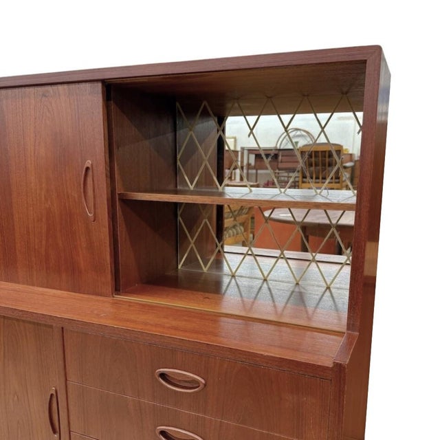 Vintage 1960s mid-century Danish modern teak highboard manufactured in Denmark. The upper half features three sliding...