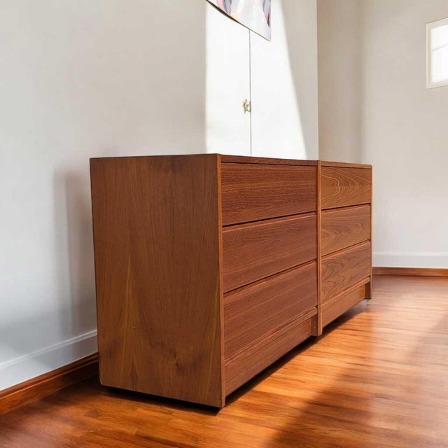 An elegant Mid-Century Modern two-piece dresser/credenza set crafted in teak wood veneer, featuring sleek clean lines,...