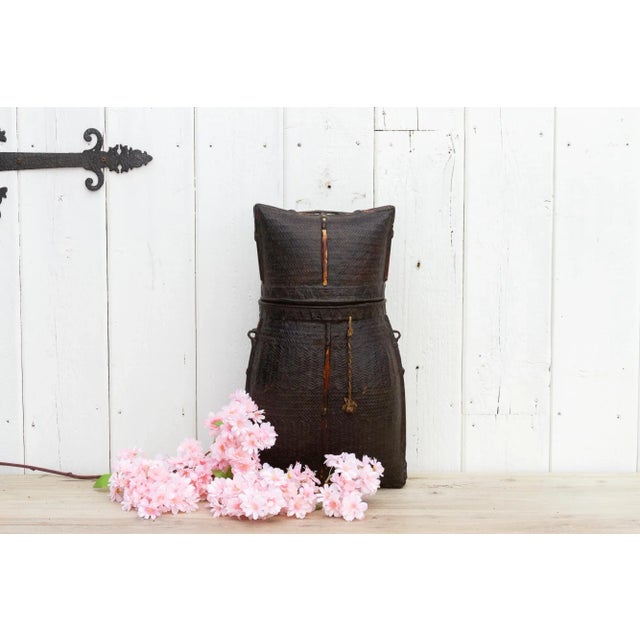 Handwoven storage basket woven by the native people from the Akha tribe in Thailand. This basket was woven utilizing a...