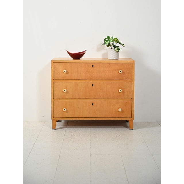 Scandinavian elm chest of drawers from the 1940s and 1950s with Bakelite corolla handles. This Scandinavian elm chest of...