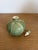 A charming handcrafted studio pottery perfume bottle with a delicate green leaf motif and soft satin glaze. The piece has...