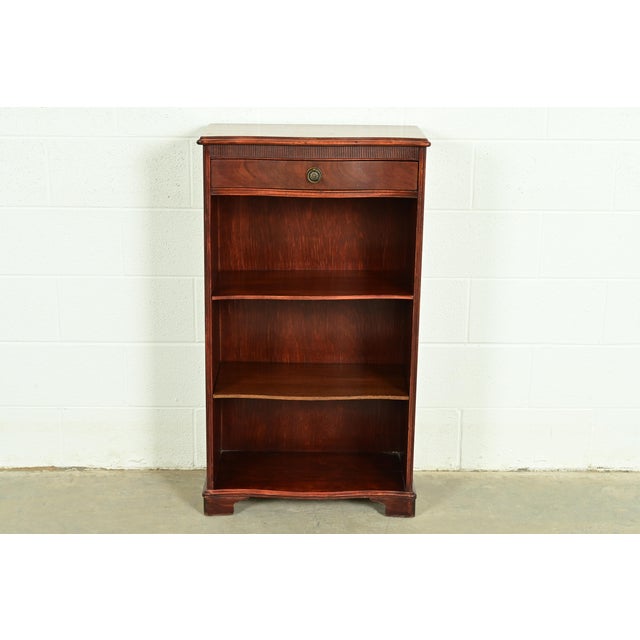 A gorgeous Georgian or Regency style bookcase By Sligh-Lowry Furniture USA, Circa 1940s Carved mahogany, with original...