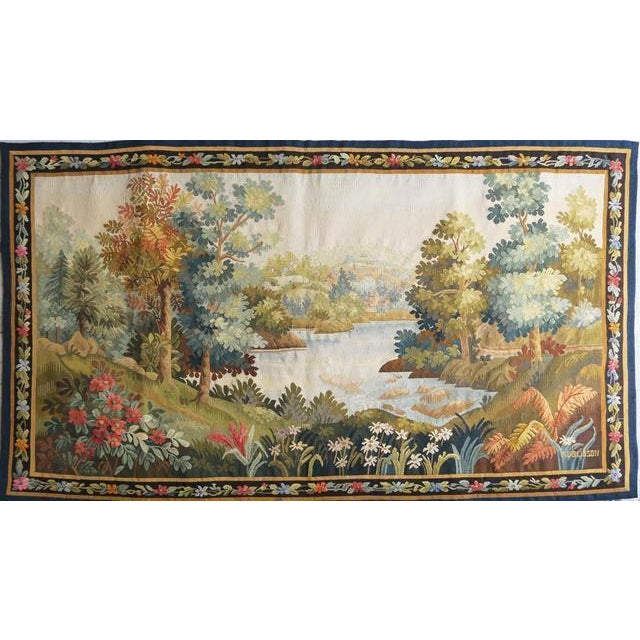 A wonderful Aubusson tapestry depicting a picturesque countryside scene. The composition features graceful trees, colorful...