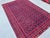 This eye-catching Andkhoy rug features a dense diamond trellis alternating between deep crimson and royal blue...