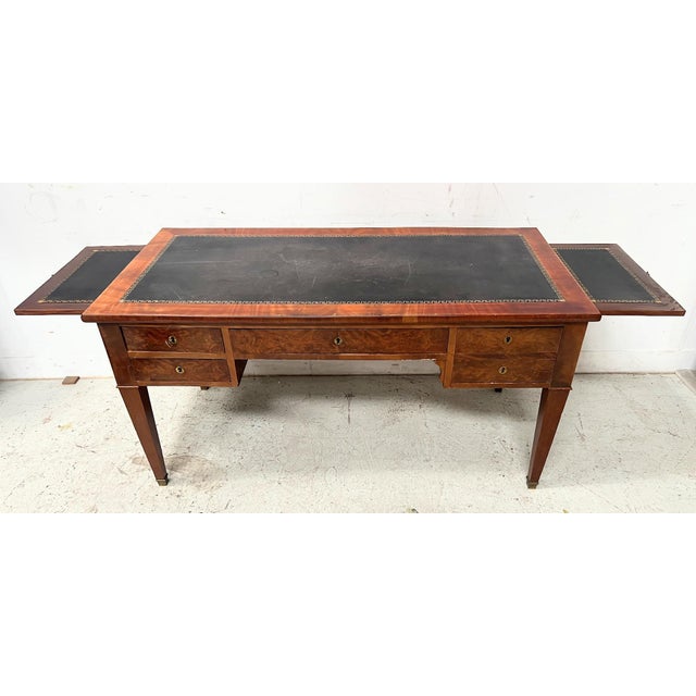 Directoire-style desk in mahogany and oak veneer Four tapered legs with bronze rings Four drawers in the frieze Two side...