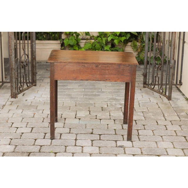 An English Georgian period oak side table from the late 18th century, with three drawers, chinoiserie hardware and...