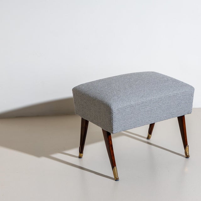 Small mid-century stool raised on splayed tapered wooden legs with brass sabots. Newly upholstered in black and white...